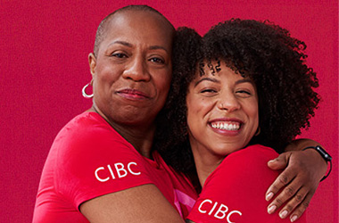 2 woman hugging wearing cibc shirts