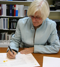 Dr. Barbara Whylie, signing letters to candidates