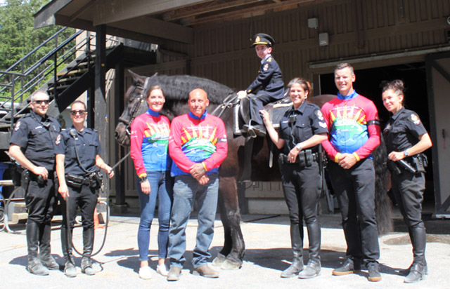 Casey Wright sitting on a horse with a group of police officers and Camp Goodtimes staff. 