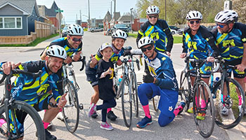 Pedal For Hope - Cops for Cancer riders, riding along a sidewalk
